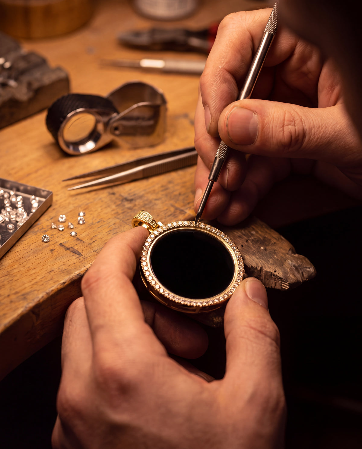 A jeweller setting a stone into the medallion at a workbench